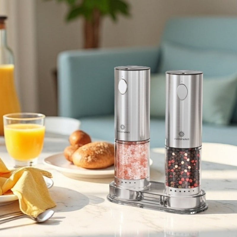 Two pepper mills on a table with food and drinks in the background