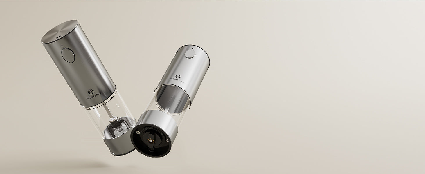Two silver electric salt and pepper grinders on a beige background