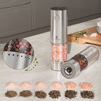 Two electric pepper mills on a kitchen counter with a close-up of peppercorns and a display of different types of salt.